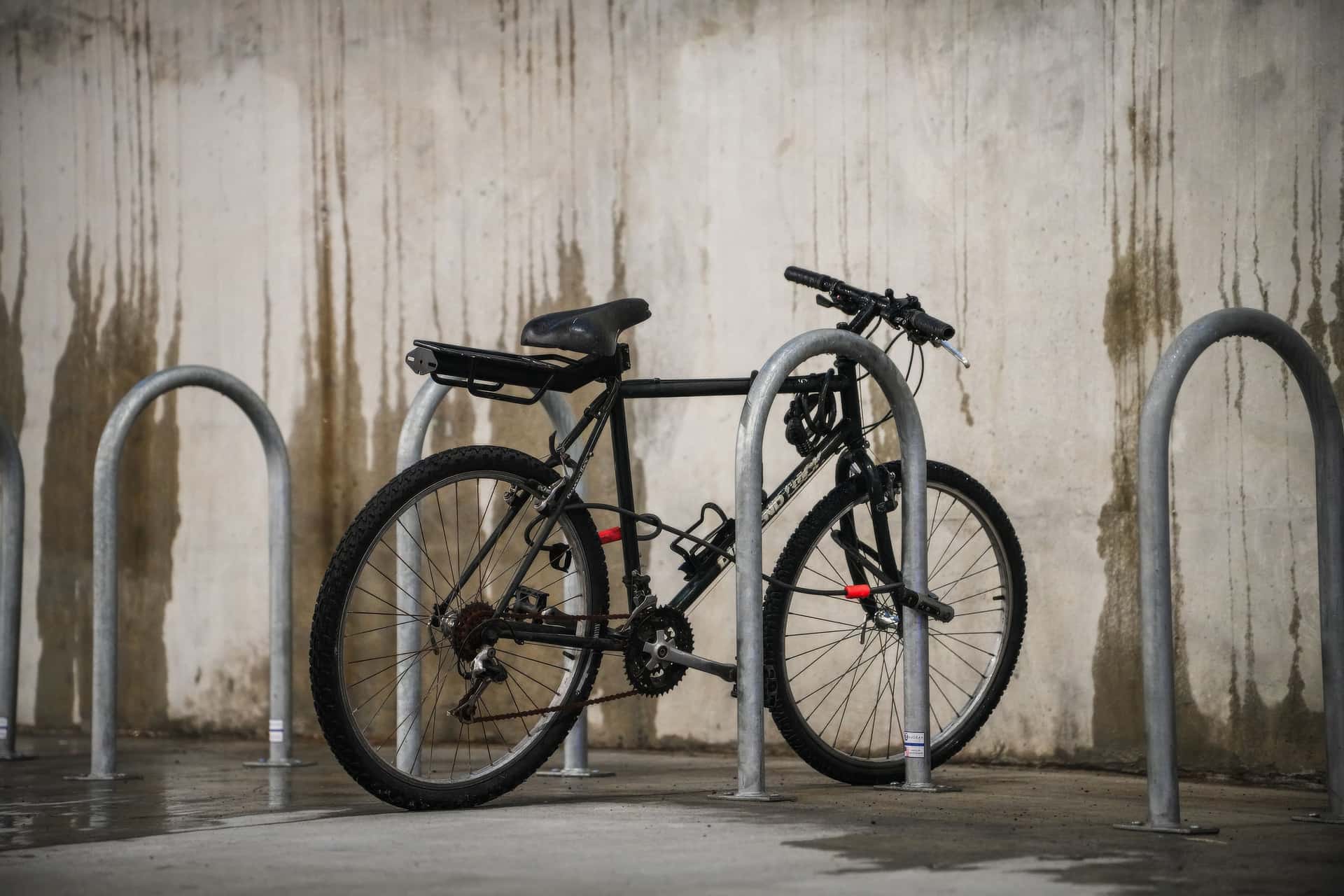 A U-lock securing a bicycle to a metal rack