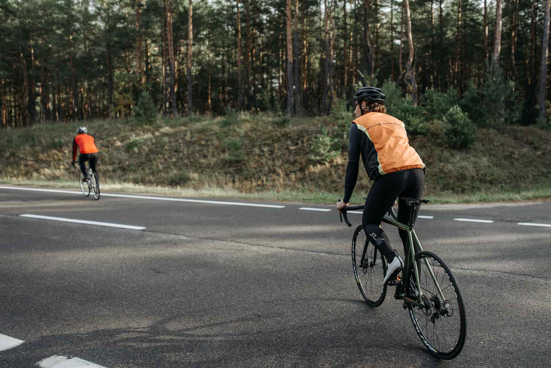 A cyclist riding on an open road at golden hour